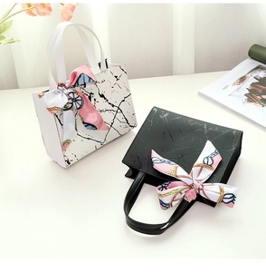 Close-up of marble pattern handbags with decorative silk scarves on arched handles