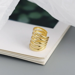 Macro view of gold multi-layered spiral ear cuff with polished metallic texture
