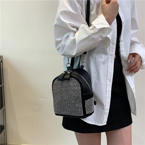 Chic black studded travel backpack shown on model with minimalist casual styling