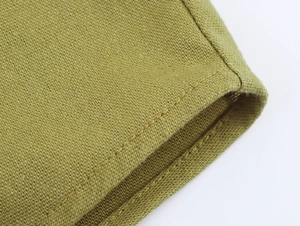 Detailed macro view of grass green linen fabric texture and premium edge stitching