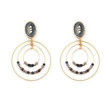 Detail of bohemian gold multi-layered circular drop earrings with beads