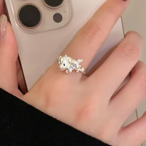 Vue détaillée d'une bague cheval en argent avec émail bleu portée au doigt