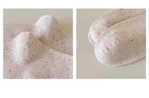 Detail of reinforced heel and flat-sewn toe on cotton knit socks with colorful speckles