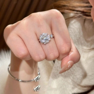 Detail of a sparkling flower-shaped zircon ring and matching silver bracelet on hand