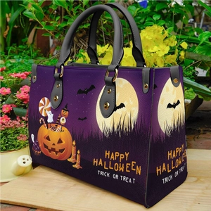 Purple Halloween PU leather tote bag with pumpkin prints on a wooden platform
