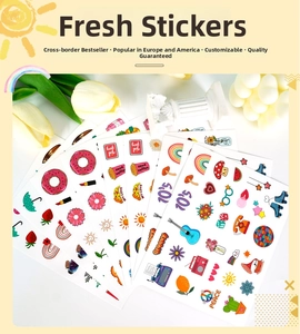 Flat lay of colorful waterproof stickers featuring rainbow and mushroom art on white desk