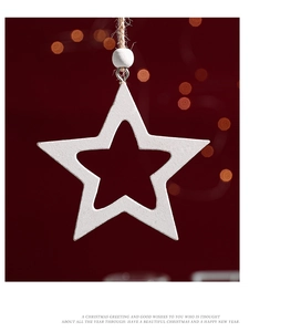 Close-up of white wooden star ornament with hollow design and rustic twine hanger
