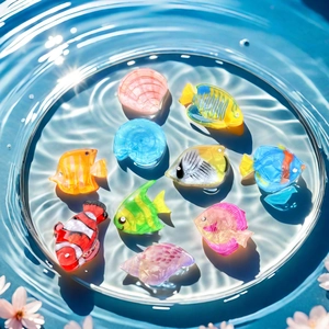 Colorful acrylic seashell and fish hair claws in a clear water bowl for vacation styling