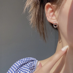 Side view of minimalist silver hollow oval stud earrings on a female model