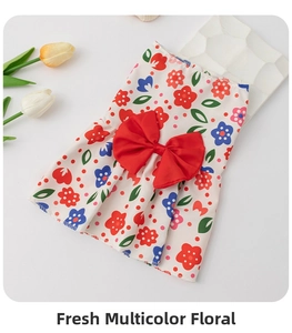 Detail of floral pet dress with a large red bow and vibrant small flower patterns