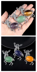 Macro detail of elk pendant brooch featuring vintage alloy and natural gemstone inlay