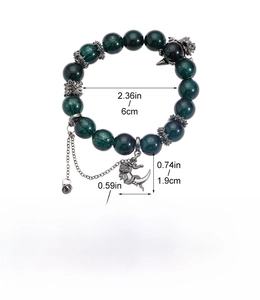 Detailed view of dark green beads bracelet with silver dragon pendant and bell charms