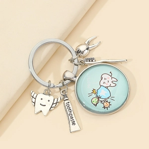 Detail of creative dental keychain with silver tooth, toothbrush and toothpaste charms