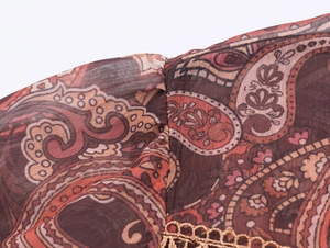 Close-up of paisley pattern on chiffon fabric with delicate lace拼接 detail