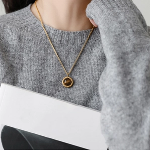 Close-up of golden rope chain necklace with a vintage brown tiger eye stone pendant