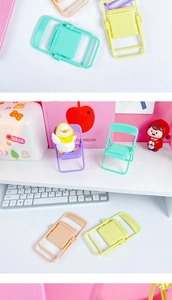 Detailed view of colorful mini folding chair phone holders in pastel colors on a desktop