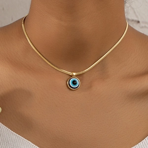 Gold snake chain necklace featuring a blue evil eye pendant on a model's neck