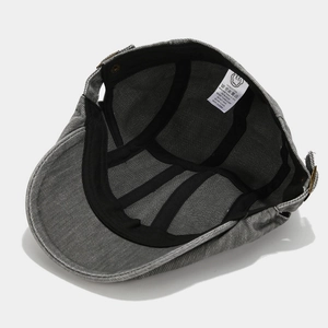 Detail view of cotton beret cap interior with black reinforcing tape and adjustable buckle