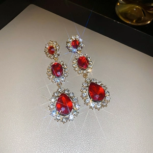 Vue macro détaillée de boucles d'oreilles vintage en strass rouge avec design à pompons
