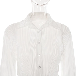 Close-up of white pleated long-sleeve shirt showing lapel collar and button detail