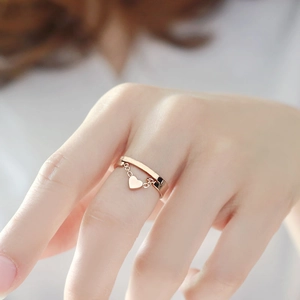 Detailed shot of double-layered rose gold heart pendant ring on model finger