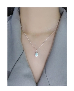 Close-up of a S925 sterling silver opal pendant necklace worn on a woman's collarbone