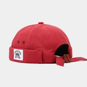 Detail of red canvas docker hat featuring Brooklyn woven label and metal adjustment strap