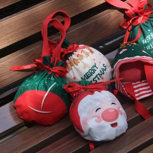 Outdoor shot of assorted Christmas drawstring gift bags with festive patterns and ribbons