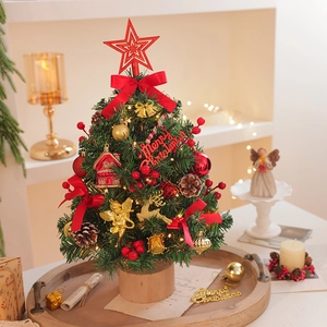 Miniature Christmas tree on wooden tray with golden bells and red bows for desk decor