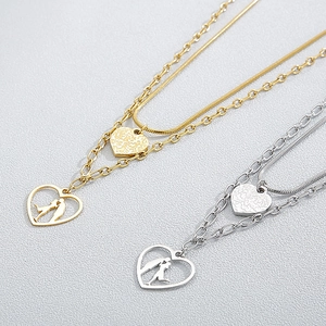 Close-up of double-layered heart necklaces featuring couple silhouettes in gold and silver