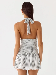 Detail of polka dot halter dress featuring a backless tie-up design and elastic waist