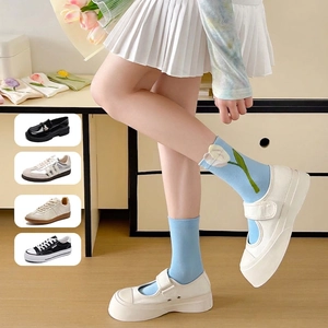 Women's light blue tulip print cotton crew socks paired with white Mary Jane shoes