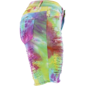 Detailed view of colorful tie-dye denim shorts featuring distressed ripped holes and raw edges