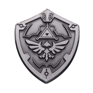 Minimalist silver shield pin with embossed bird and triangle motifs on white background