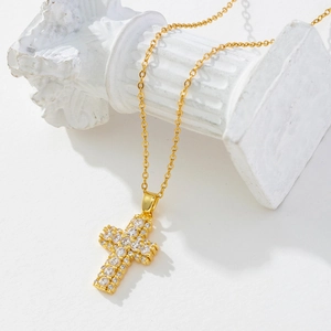 Close-up of gold-plated cross pendant with sparkling white cubic zirconia micro-pave