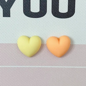 Macro view of colorful 3D resin heart charms in yellow and orange for DIY crafting