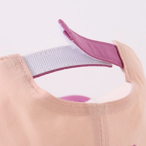 Macro detail of infant baseball cap with adjustable velcro strap in purple and pink