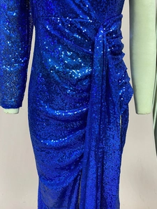 Dettaglio del ricamo in paillettes blu elettrico e design a portafoglio sull'abito da sera