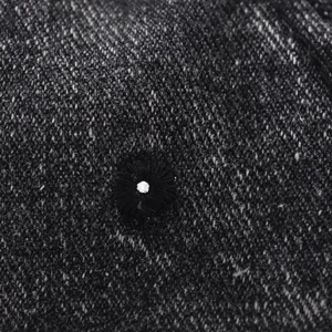 Close-up of vintage washed denim baseball cap featuring twill texture and embroidered eyelet