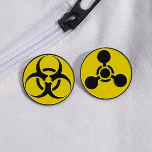 Eco-friendly biohazard and radiation symbol enamel pins on a white canvas bag