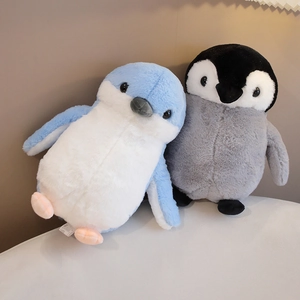 Close-up of plush penguin toys in grey and blue with soft fabric texture and detailed stitching