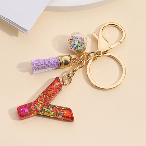 Detailed close-up of resin letter Y keychain with colorful sequins and purple tassel