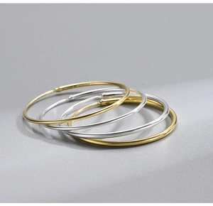 Macro shot of minimalist S925 sterling silver hoop earrings in gold and silver finishes