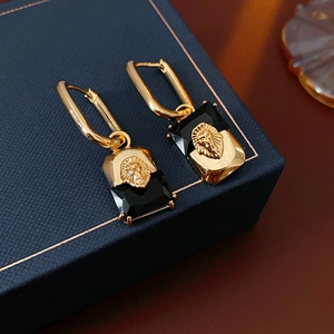 Detail of vintage lion head earrings with gold plating and black rectangle crystal