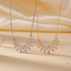 Detail of gold and silver teardrop zircon necklaces on champagne satin background