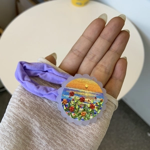 French style purple scrunchie with sunflower embroidery worn on a lace sleeve wrist