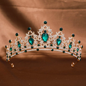 Elegant gold bridal tiara with green emerald gemstones and sparkling rhinestones on satin