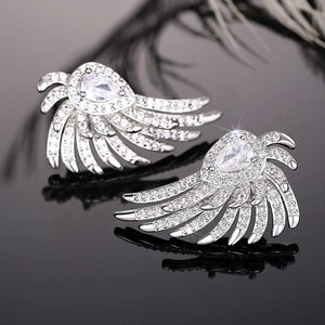Elegant silver angel wing stud earrings with white zircon on a black reflective surface