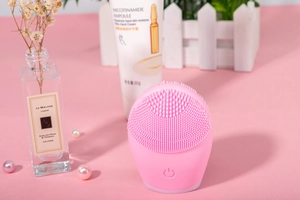 Macro shot of pink silicone facial cleanser with soft touch points and power button