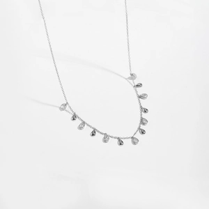 Macro detail of S925 silver long necklace featuring pear-shaped teardrop zircon pendants